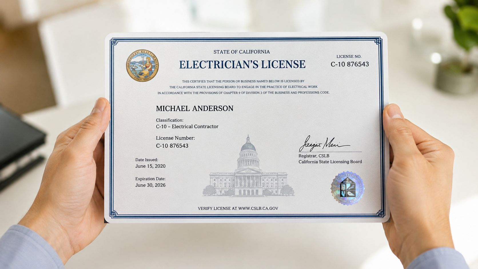 En person holder et officielt elektriker-licenscertifikat fra staten Californien frem mod kameraet for at vise det.