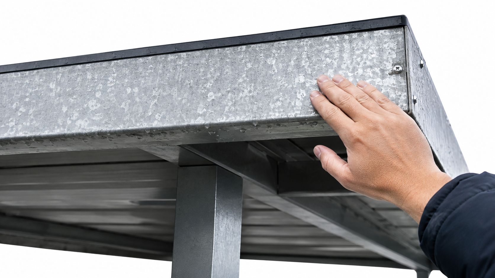 En hånd rører ved hjørnet af en moderne carport konstrueret i holdbart, vejrbestandigt galvaniseret stål.
